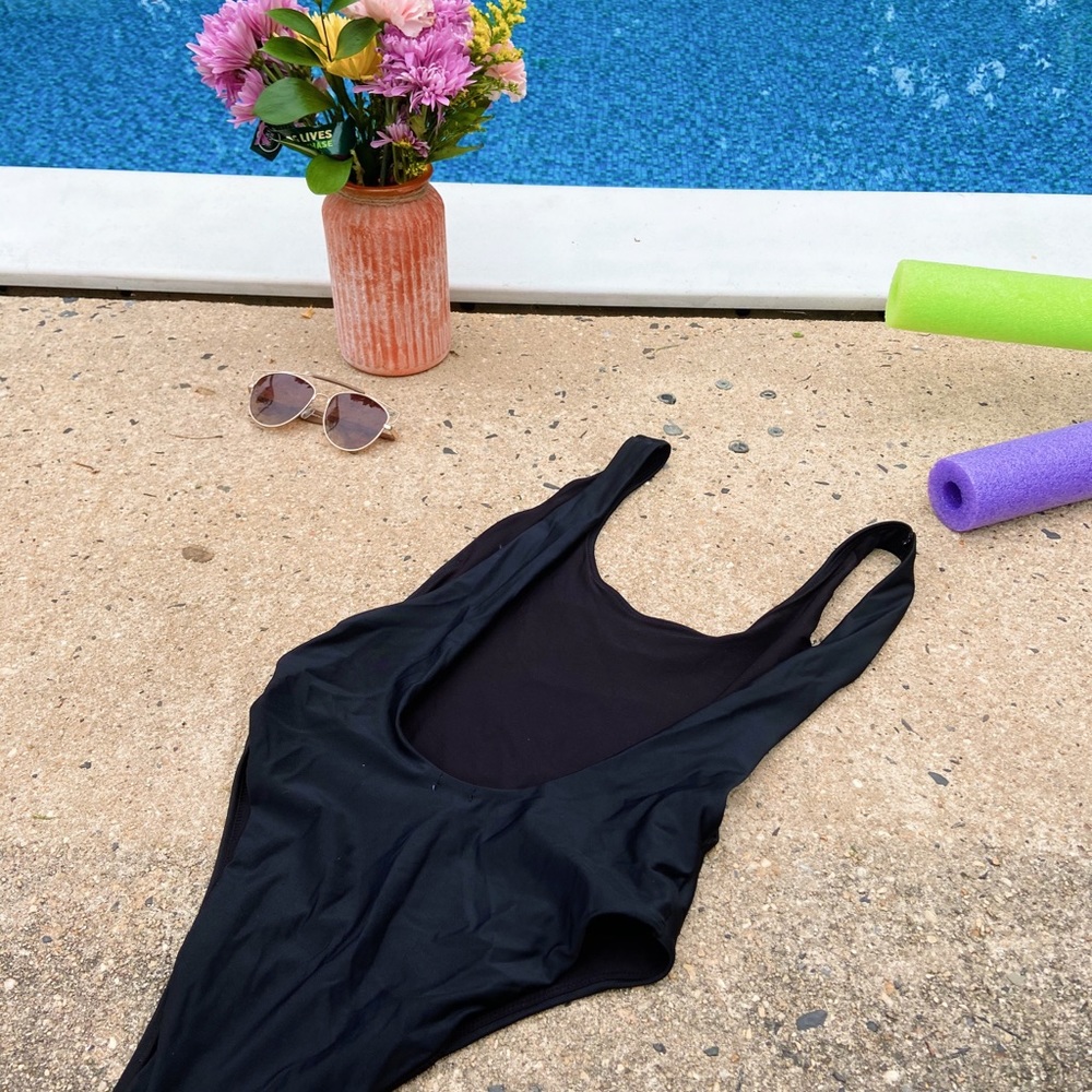Black one piece suit with plunging back